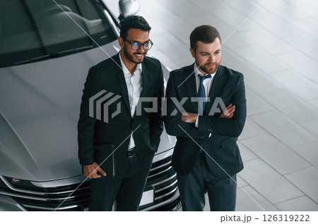 View from the top. Two businessmen are working together in the car showroom View from the top. Two businessmen are working together in the car showroom 126319222
