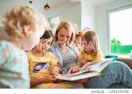 Enjoying story time together in a cozy living room Enjoying story time together in a cozy living room 126319298