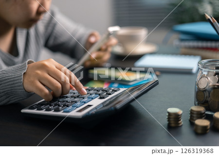 Finance bank tax expense accounting budget money businessman hand use calculator Financial calculate accountant close up calculator with graph chart write office desk Business expense analysis saving 126319368