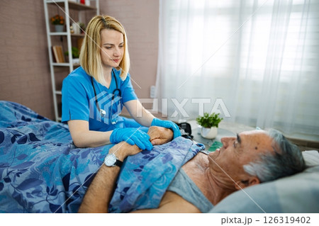 Nurse providing compassionate care to elderly patient 126319402