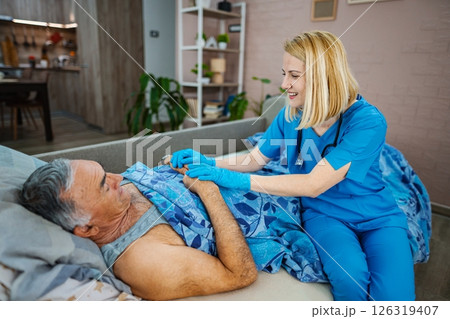 Caring nurse provides comfort to patient at home Caring nurse provides comfort to patient at home 126319407