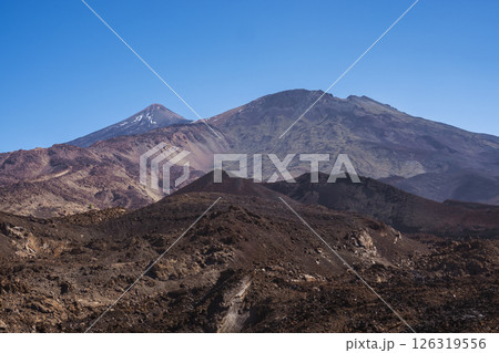 Winter view on colorful volcano Pico del Teide with snow spots from hiking trail Samara. Mountains and lava fields against blue sky. El Teide National Park, Tenerife, Canary Islands, Spain Winter view on colorful volcano Pico del Teide with snow spots from hiking trail Samara. Mountains and lava fields against blue sky. El Teide National Park, Tenerife, Canary Islands, Spain 126319556