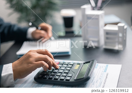 Finance bank tax expense accounting budget money businessman home for Business expense analysis saving use Financial calculate accountant close up calculator with graph chart hand write office desk 126319912