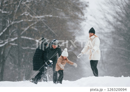 Playing snowballs. Happy family is outdoors, enjoying snow time at winter together 126320094