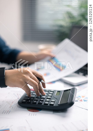 Finance bank tax expense accounting budget money businessman hand use calculator Financial calculate accountant close up calculator with graph chart write office desk Business expense analysis saving 126320114