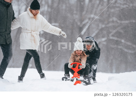 Sled ride. Happy family is outdoors, enjoying snow time at winter together Sled ride. Happy family is outdoors, enjoying snow time at winter together 126320175