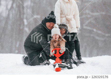 Sled ride. Happy family is outdoors, enjoying snow time at winter together 126320176