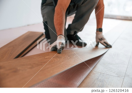 Close up view. Man is installing new laminated wooden floor 126320416