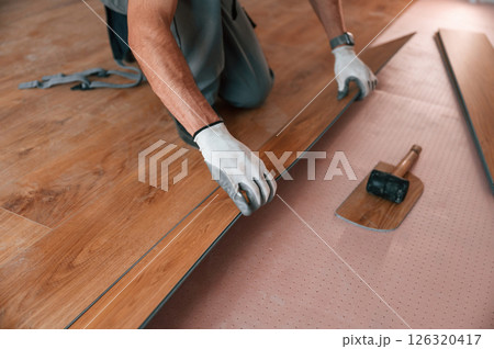 Close up view. Man is installing new laminated wooden floor 126320417
