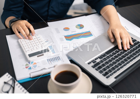 Finance bank tax expense accounting budget money businessman hand use calculator Financial calculate accountant close up calculator with graph chart write office desk Business expense analysis saving 126320771