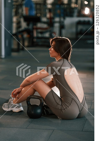 Rear view. Beautiful woman with sport body type is in the gym Rear view. Beautiful woman with sport body type is in the gym 126320852
