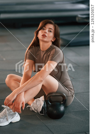 Sitting and having a break. Beautiful woman with sport body type is in the gym 126320857
