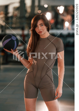 Portrait of beautiful woman with sport body type that is in the gym. Holding fitness ball 126320909