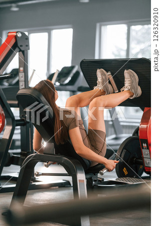 Doing exercises for the legs. Beautiful woman with sport body type is in the gym 126320910