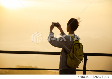 Man traveler with camera backpack hiking outdoor travel lifestyle and adventure concept. cap backpack and join of tourist for green mountain tour, beauty of nature and expansive sky people of tourism Man traveler with camera backpack hiking outdoor travel lifestyle and adventure concept. cap backpack and join of tourist for green mountain tour, beauty of nature and expansive sky people of tourism 126321205