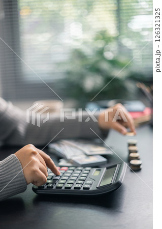 Finance bank tax expense accounting budget money businessman hand use calculator Financial calculate accountant close up calculator with graph chart write office desk Business expense analysis saving 126321325