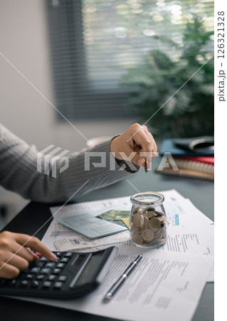 Finance bank tax expense accounting budget money businessman hand use calculator Financial calculate accountant close up calculator with graph chart write office desk Business expense analysis saving 126321328