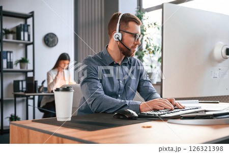 Man is using computer. Two employees are working together in the modern office 126321398