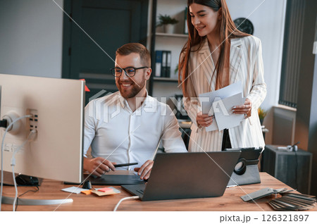 Designers are talking and working. Two employees are together in the modern office Designers are talking and working. Two employees are together in the modern office 126321897