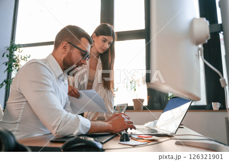 Side view. Paper work. Two employees are together in the modern office Side view. Paper work. Two employees are together in the modern office 126321901