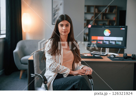 Sitting on the chair. Designer's software on the screen. Woman is working in the modern office with computer 126321924