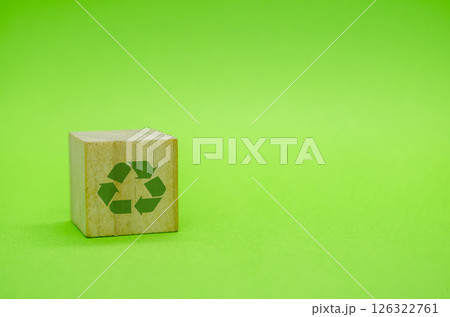 Recycle symbol with wooden blocks on green background. Promoting reuse, reduce, and recycle for sustainability 126322761