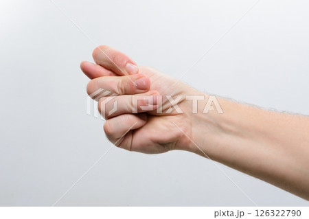 Hand making a fig sign gesture against a plain background. Hand making a fig sign gesture against a plain background. 126322790