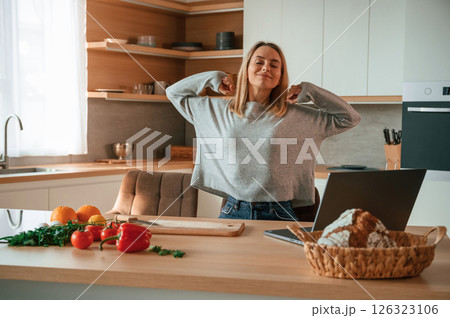 Morning stretching. Beautiful young woman is on the kitchen Morning stretching. Beautiful young woman is on the kitchen 126323106