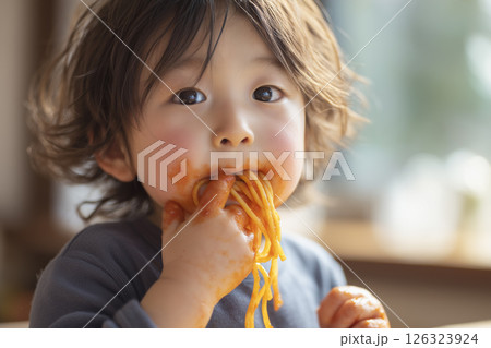 ナポリタンを夢中で頬張る子ども 126323924