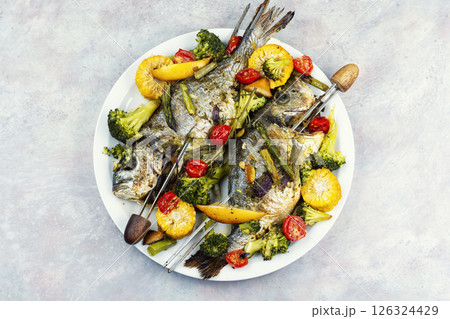 Baked dorado fish with asparagus and vegetables. 126324429