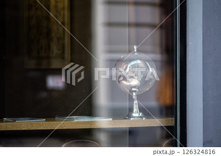 glass globe on table, view through window with street reflections, copy space glass globe on table, view through window with street reflections, copy space 126324816