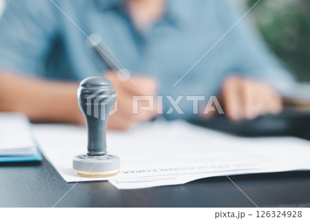 Businessman hands stamp approve on financial business approval document paper. Man hand accepted permit contract agreement. Broker manager sign contract bank guarantee approved stamp application form 126324928
