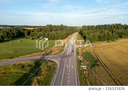 Aerial View of a Rural Road Intersection With Trees and Fields on a Sunny Day 126325826