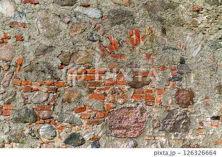A textured wall made of stones and bricks reveals layers of history in a rustic setting 126326664
