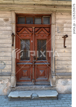 Beautifully carved wooden double doors of an old building in a historic district on a sunny day Beautifully carved wooden double doors of an old building in a historic district on a sunny day 126326676