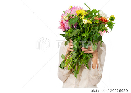 Unrecognizable woman holding a bouquet of multi-colored dahlias in her hand close-up on a white background. 126326920