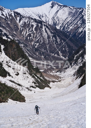 春の針ノ木岳雪渓から振り返って爺ヶ岳と登る山スキーヤーを望む 126327504