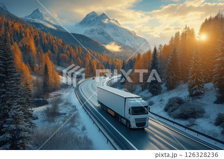 White transport truck on scenic snowy mountain road at sunset, winter logistics 126328236