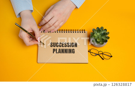 Succession planning. Strategic process of identifying, training, and preparing employees to fill key leadership roles to ensure business continuity and long-term success. A woman writes a notes Succession planning. Strategic process of identifying, training, and preparing employees to fill key leadership roles to ensure business continuity and long-term success. A woman writes a notes 126328817