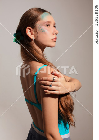 Girl model with creative blue makeup posing on gray background. Girl model with creative blue makeup posing on gray background. 126329106