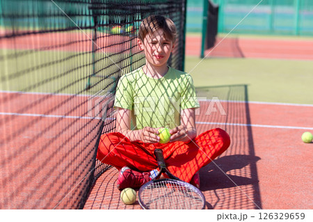 Boy athlete near tennis net with racket and ball. Children's sport. Boy athlete near tennis net with racket and ball. Children's sport. 126329659