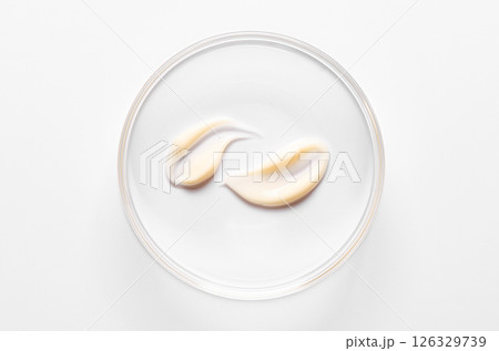 A sample of cosmetic moisturizing or anti-aging cream in a petri dish. 126329739