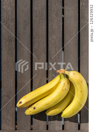 bunch of bananas on the table on terrace with early morning sunlight shines through 126329932