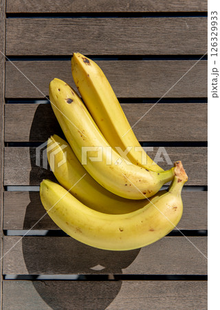 bunch of bananas on the table on terrace with early morning sunlight shines through 126329933