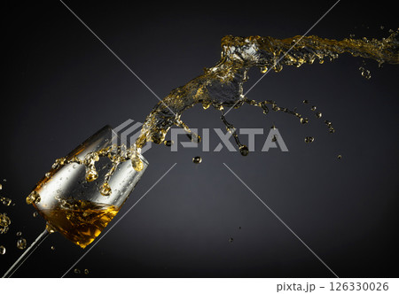 Glass and white wine splash on a black background. Glass and white wine splash on a black background. 126330026