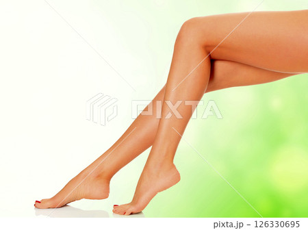 Perfect long female legs on green blurred background. Perfect long female legs on green blurred background. 126330695