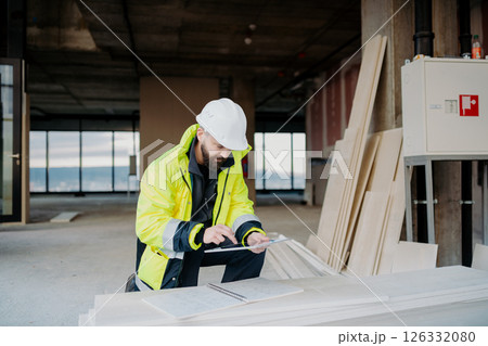 Construction site manager using digital tablet to inspect building progress. 126332080