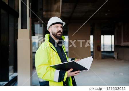 Engineer overseeing city construction project, reading documentation. Engineer overseeing city construction project, reading documentation. 126332081