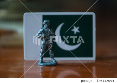 A tin soldier on the background of the flag of Pakistan. India Pakistan military conflict 126332094