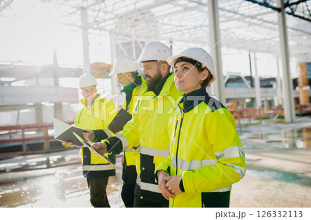 Team of engineers and construction workers inspecting building progress. Team of engineers and construction workers inspecting building progress. 126332113